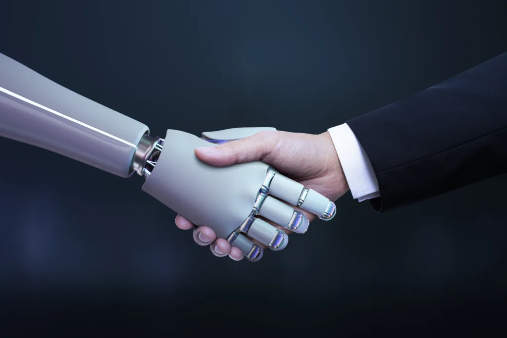  A human hand in a business suit engages in a handshake with a metallic robot hand, representing Deloitte's partnership between human intelligence and AI technology for digital transformation