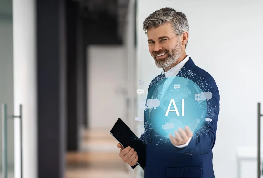 : A cheerful middle-aged businessman in a blue suit presenting a floating AI hologram from his digital tablet, portraying the integration of AI technology in modern business environments.