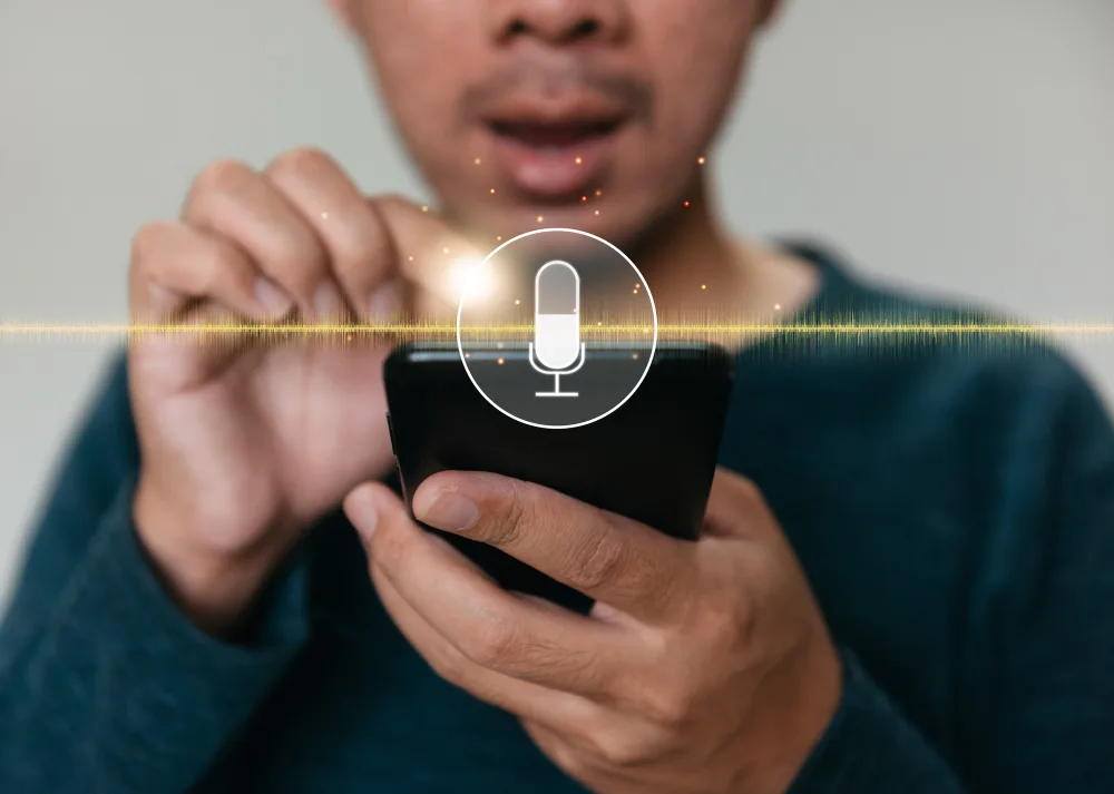 A man speaks into a smartphone, with a graphic of an audio waveform and a microphone icon overlaid, symbolizing voice recognition technology by an AI startup.