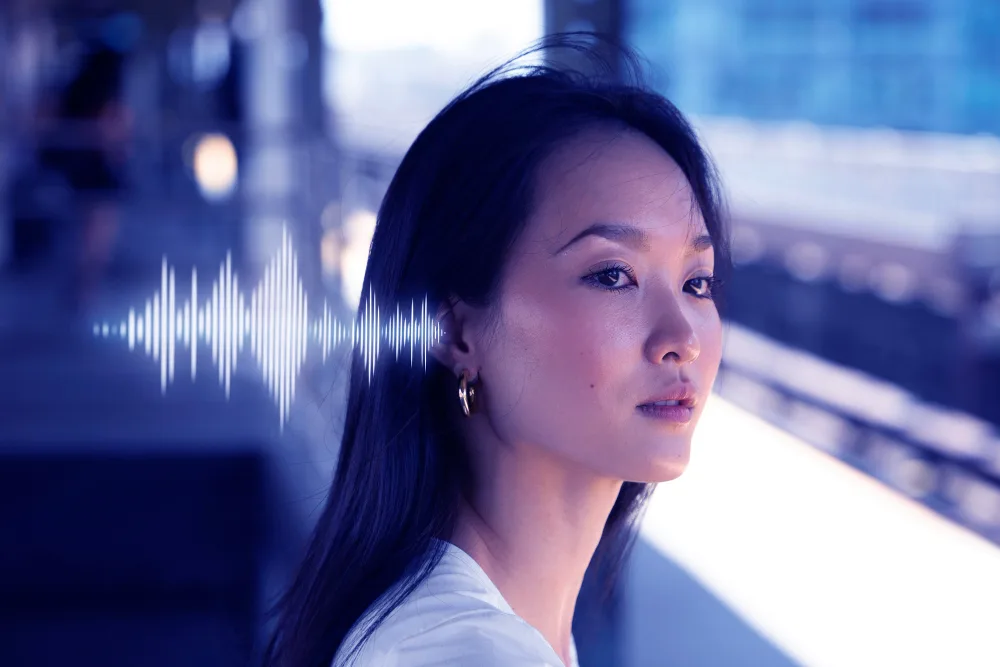 Portrait of a woman with a serene expression, with a digital audio waveform graphic overlay, representing the innovative voice AI technology of a startup that achieved unicorn status.