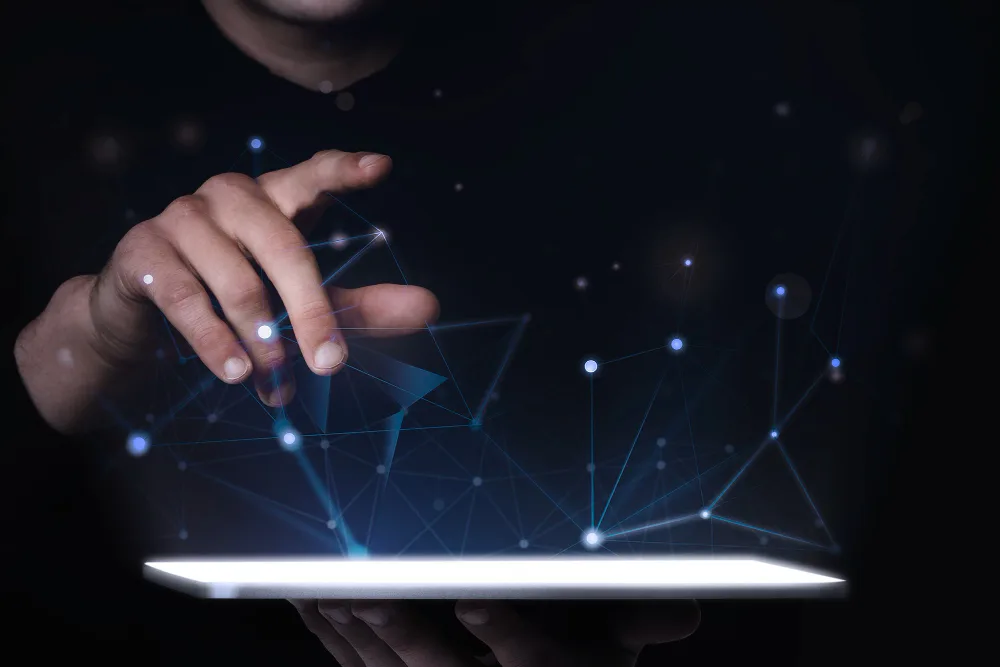 A hand hovers above a tablet with a glowing, interconnected network of nodes, symbolizing cutting-edge marketing innovation and strategic B2B content marketing in the digital space.