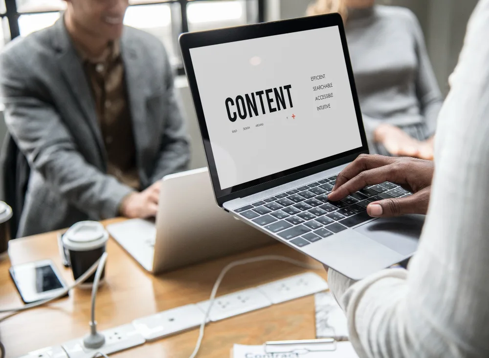 Laptop screen displaying the word 'CONTENT' with various attributes listed, over a blurry background of business professionals, suggesting a focus on content writer selection for healthcare B2B marketing