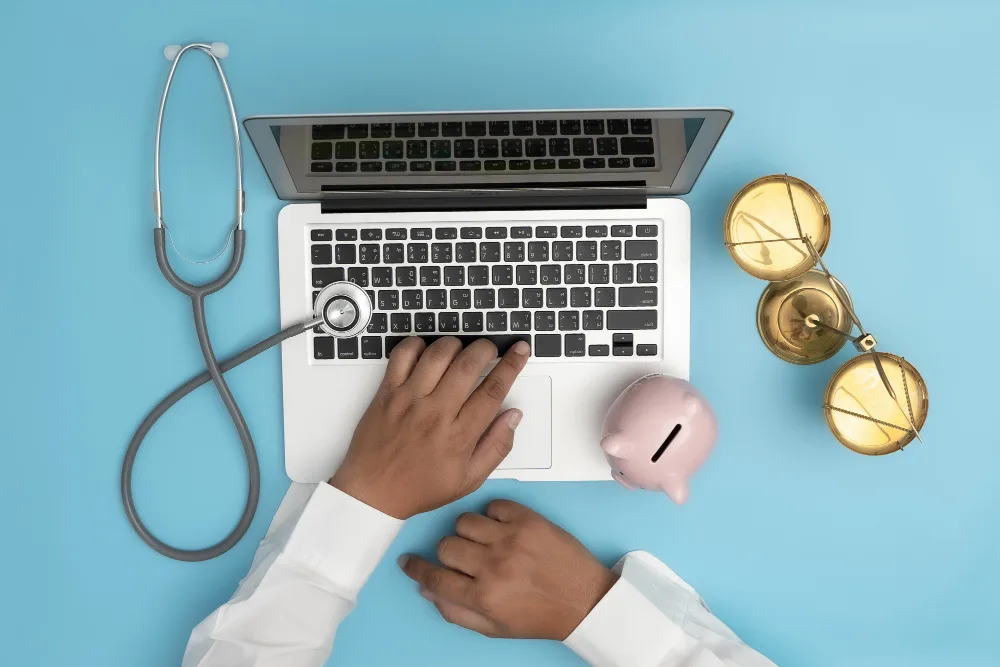 Healthcare professional using a laptop with a stethoscope and scales of justice, symbolizing the balance of healthcare knowledge and legal or financial acumen in B2B content creation.
